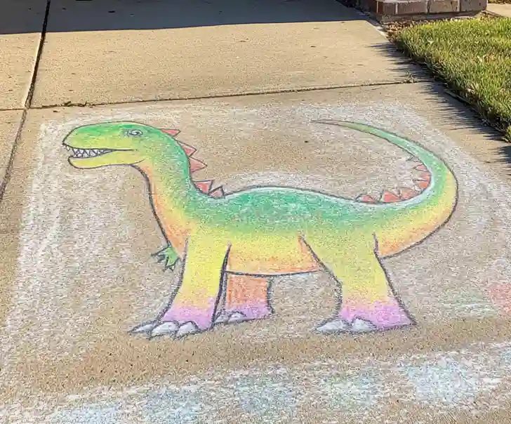 Simple dinosaur chalk drawing on pavement