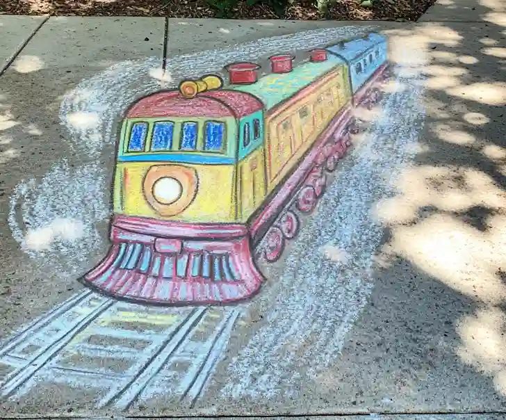 Chalk drawing of a cartoon train on the sidewalk