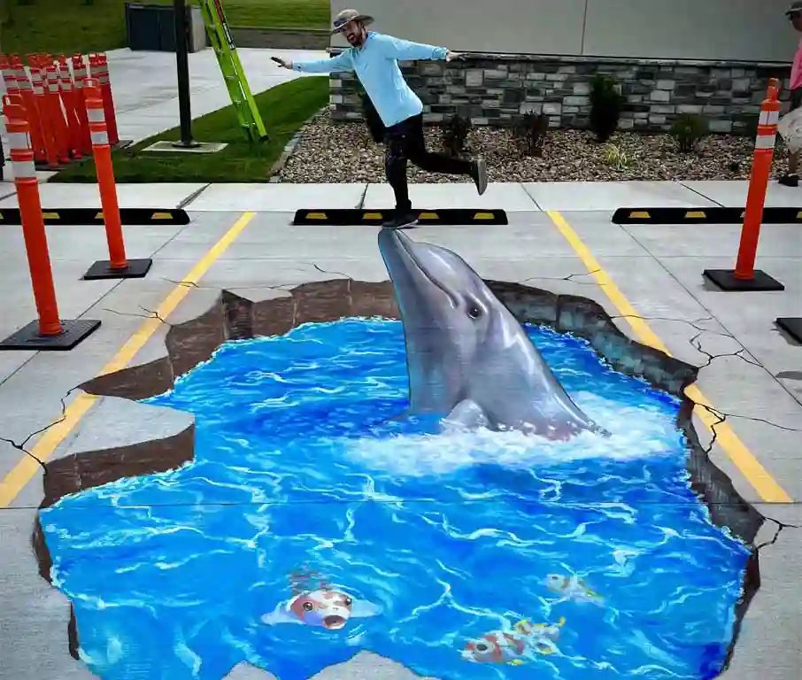 3D chalk art of a dolphin leaping out of the pavement